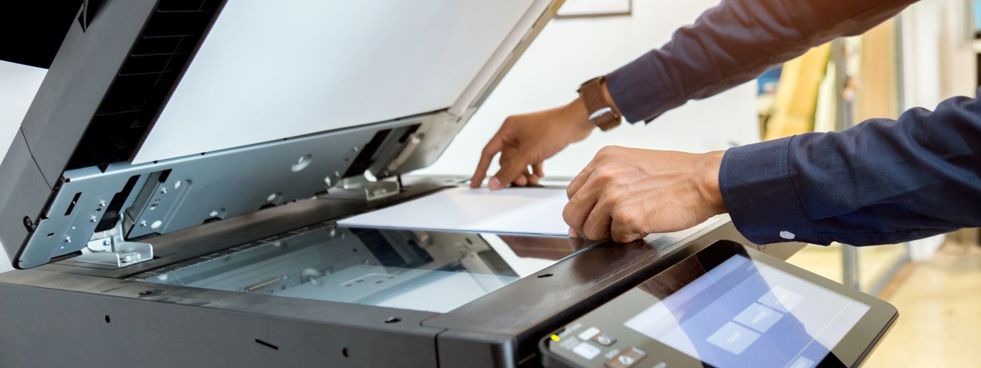 Mann scant ein Blatt Papier in einem Scanner ab.